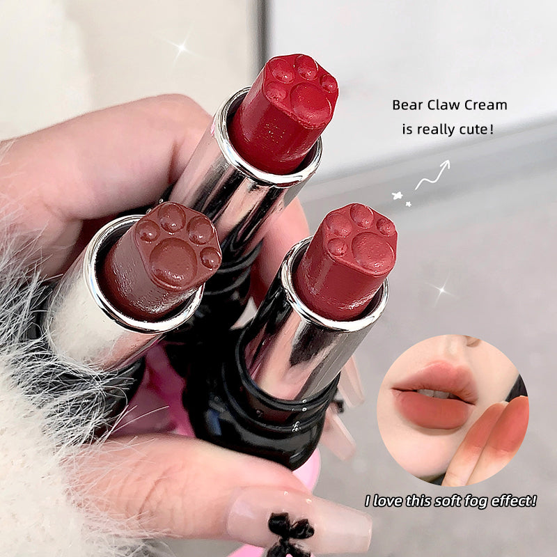 Three lipsticks with paw-shaped caps held by a hand, with close-up shots of lips wearing the lipsticks.
