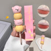 Pink and yellow bear-shaped lip balm with packaging on a neutral background