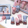 Set of cute bear-shaped lip balms with packaging on a white surface