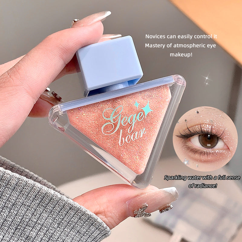 Makeup product with 'Gege bear' branding held by a hand, close-up of eye makeup application.