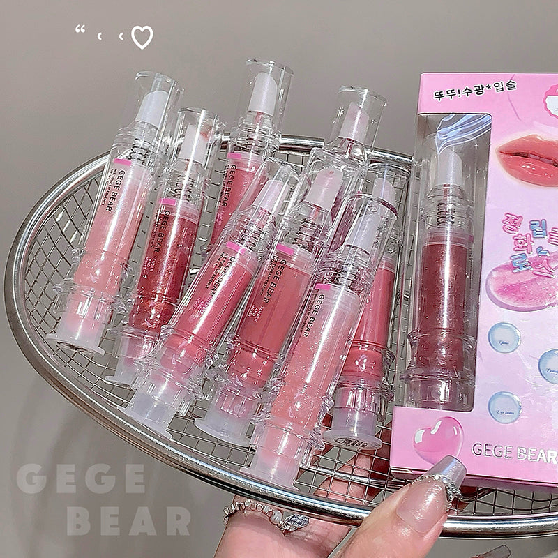 Collection of pink lip glosses on a metal tray with 'GEGE BEAR' branding.