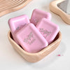 Pink soap bars with 'Baby Bear' text in a wooden holder on a light background