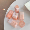 Collection of pink cosmetic containers on a white surface