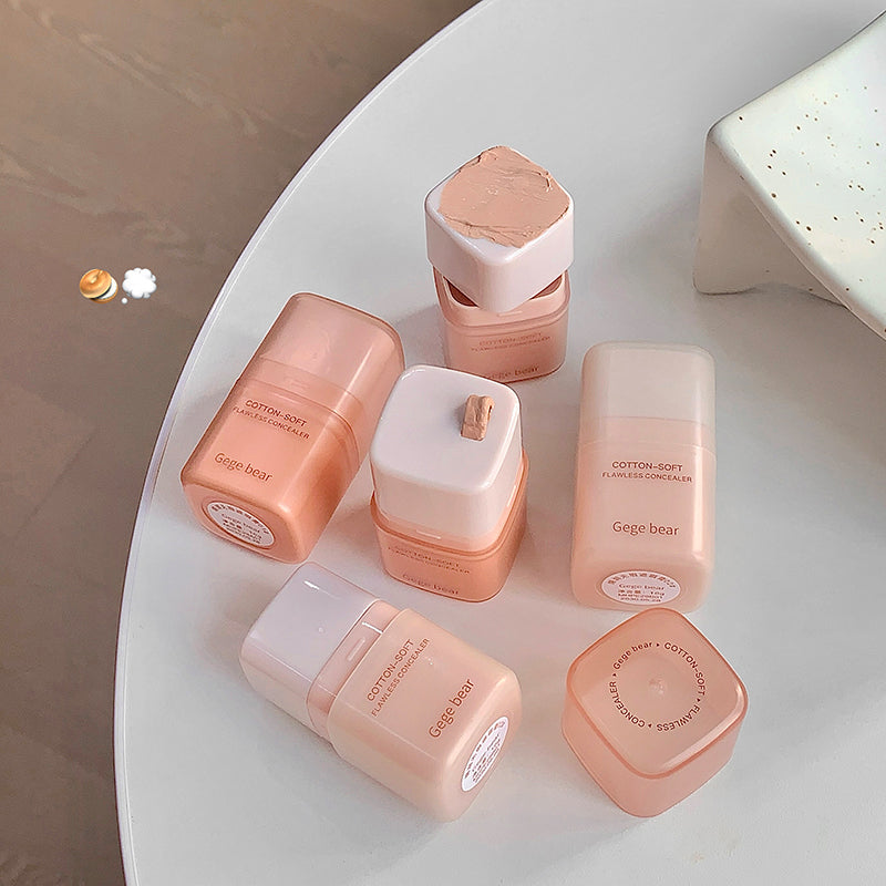 Collection of pink cosmetic containers on a white surface