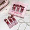 Set of pink lip glosses with a 'Gege bear' box on a white surface.