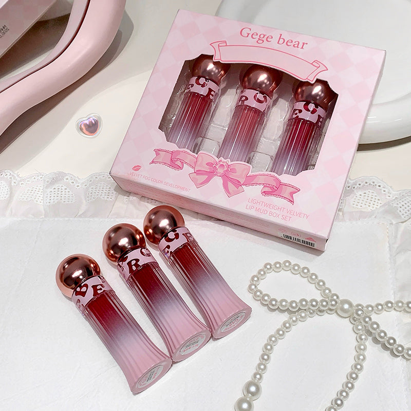 Set of pink lip glosses with a 'Gege bear' box on a white surface.