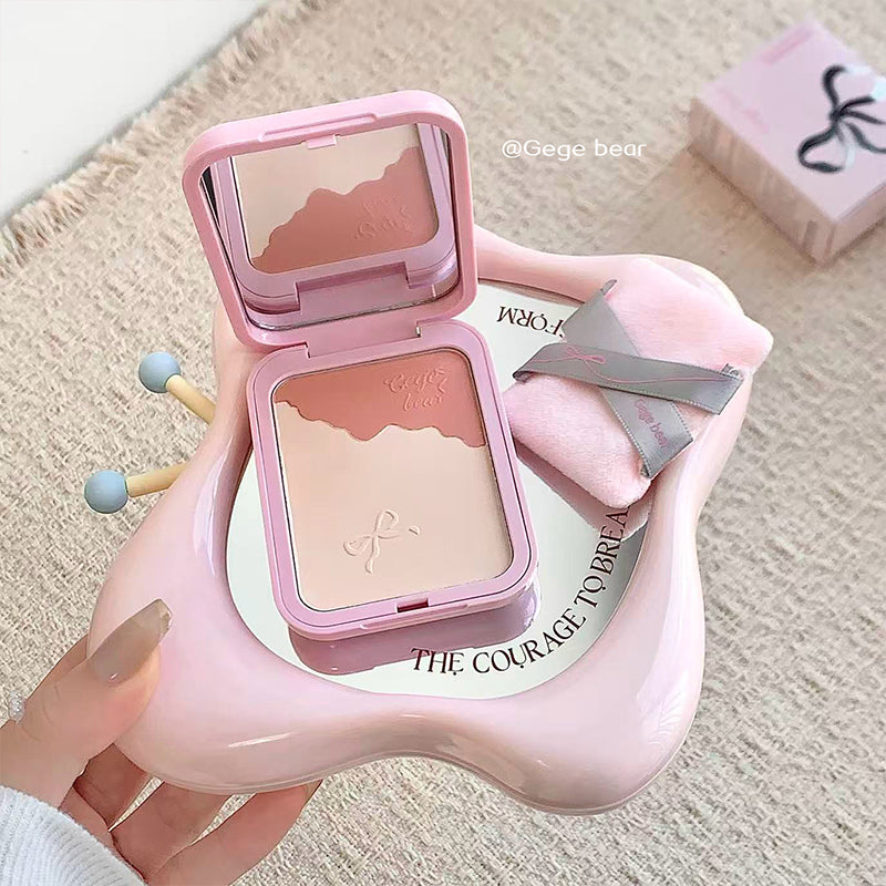Pink makeup compact held by a hand on a textured surface