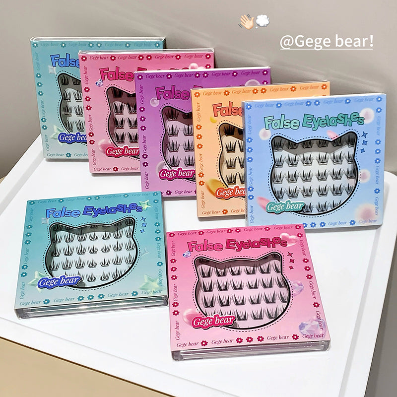 Set of false eyelashes in various colorful boxes on a white surface.