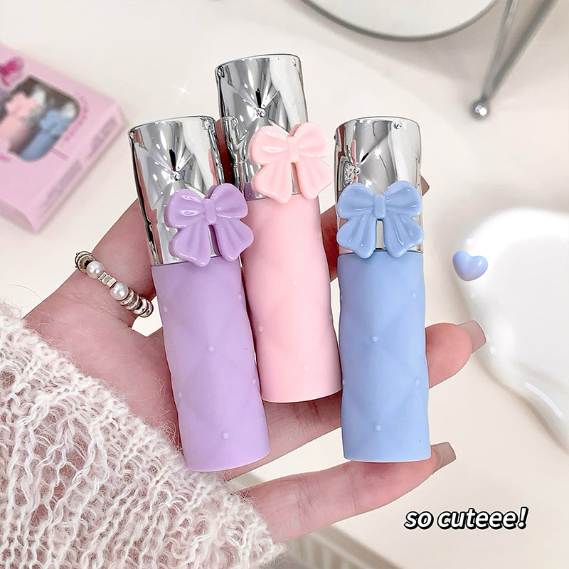 Three small cylindrical products with bow decorations held in a hand, with text 'so cuteee!'.