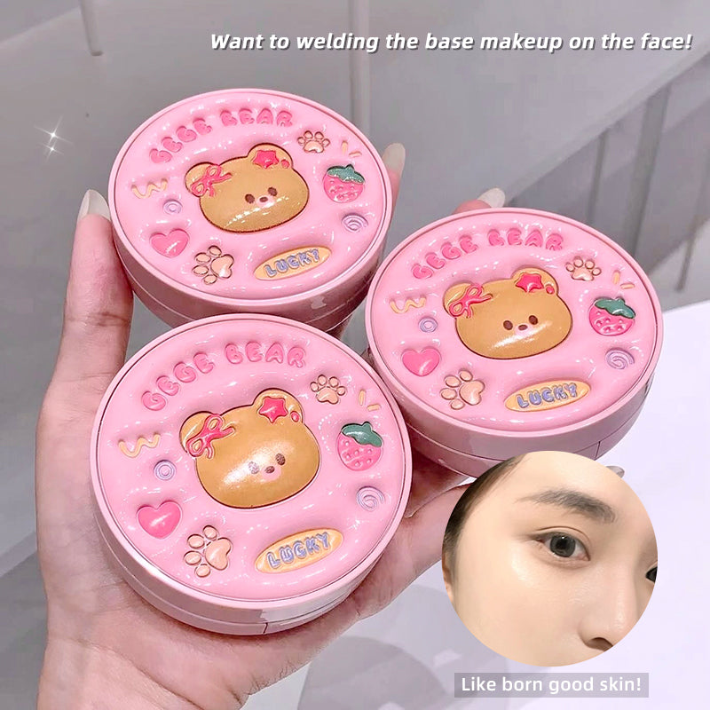Three pink compact mirrors with bear design held by a hand, with text about base makeup.