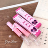 Pink lip gloss with packaging on a wooden surface