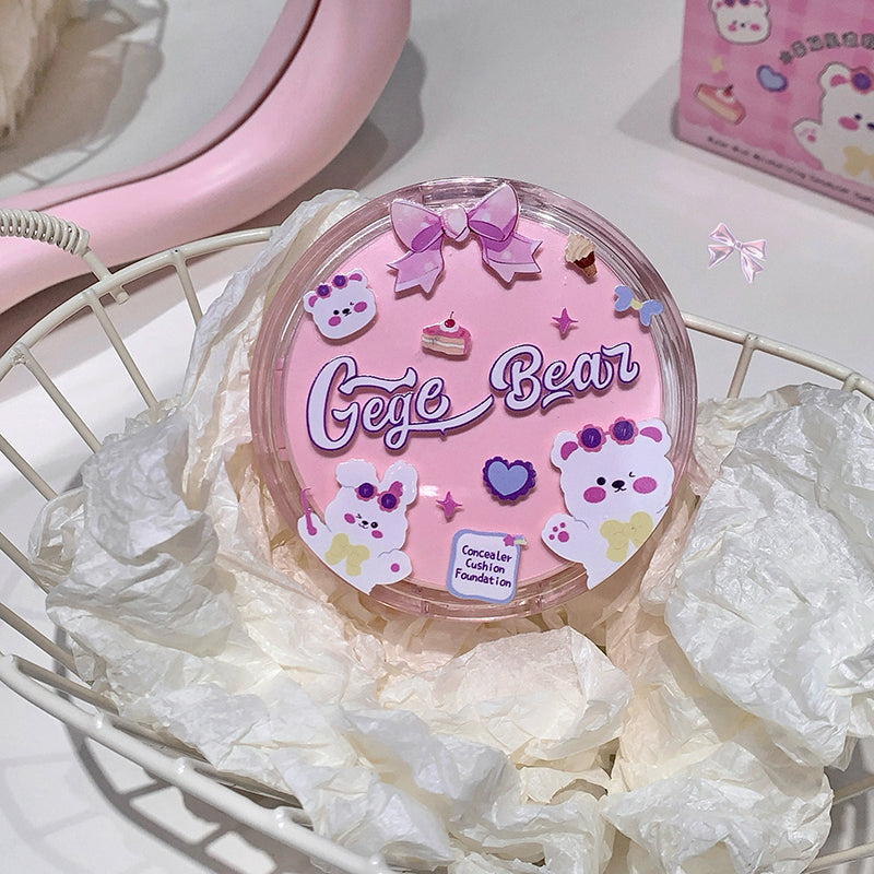 Pink 'Gege Bear' cushion with decorative elements on a white surface