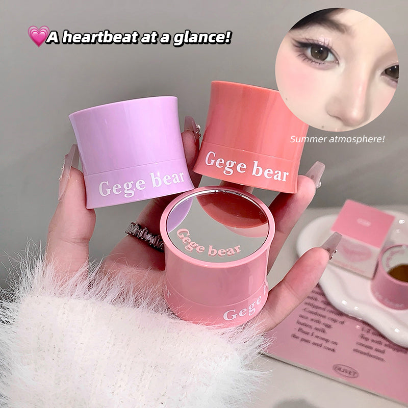 Three pink containers labeled 'Gege bear' held by a hand with a blurred background.