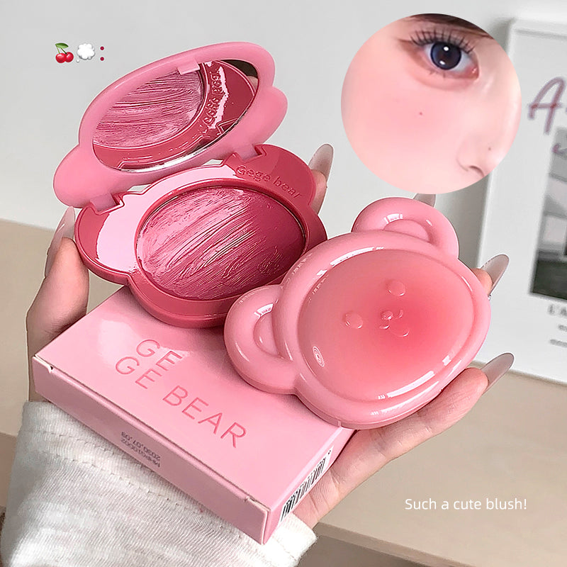 Pink blush compact with bear design held by a hand, with 'GE GE BEAR' branding.