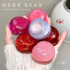 Hand holding multiple small containers of lip and cheek cream with 'GEGE BEAR' branding.