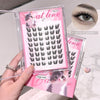 False eyelashes packaging with pink design and cat illustrations, held by a hand.
