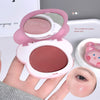 Compact blush with mirror and pink bunny design held by a hand, with close-up of blush on skin.
