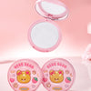 Compact powder with a mirror and two round containers on a pink background, featuring a bear design.