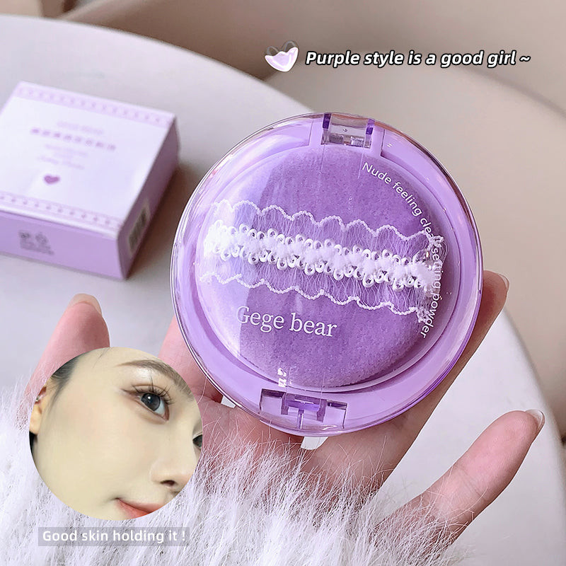 Purple compact mirror held by a hand with a visible brand name, set against a light background.