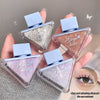 Four small cosmetic containers with glittery contents held by a hand, with a close-up of an eye in the corner.
