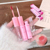 Set of pink lip products including lip glosses and applicators held by a hand.