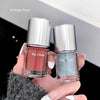 Two bottles of Gege bear nail polish held by a hand with white nail polish.