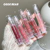 Set of GEGE BEAR lip glosses held by a hand with a neutral background