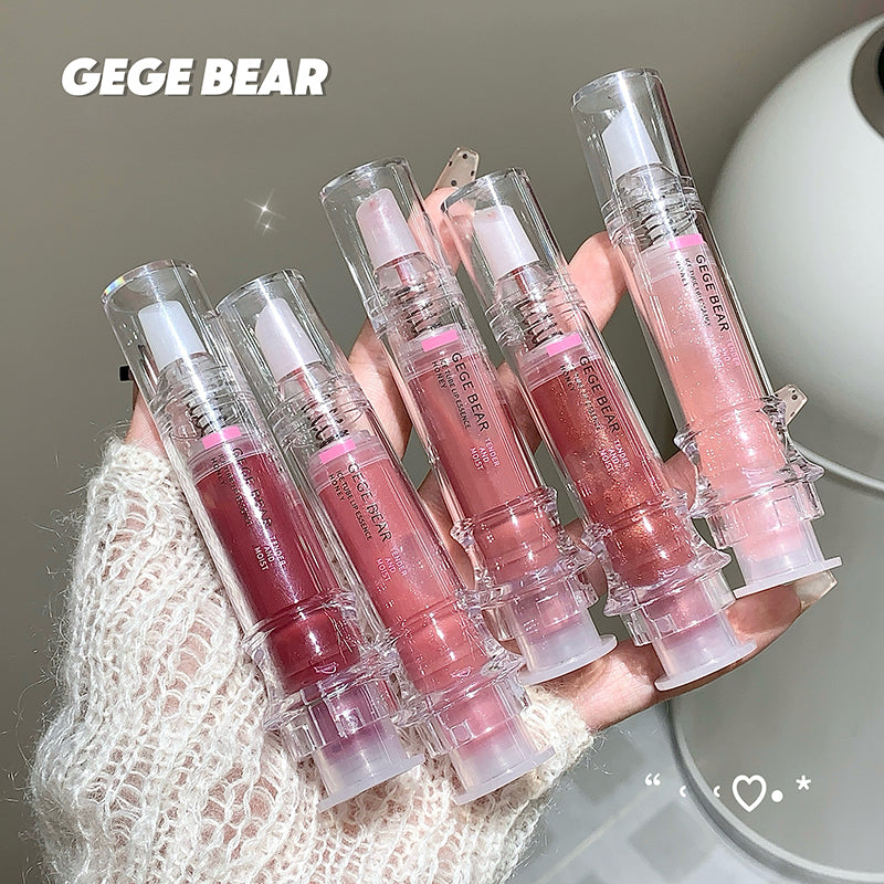 Set of GEGE BEAR lip glosses held by a hand with a neutral background