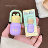 Small purple bottle with green cap held by a hand, next to its packaging labeled 'Gege Bear'.