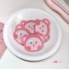 Pink bear-shaped pacifiers in a white dish with 'Gege bear' branding.