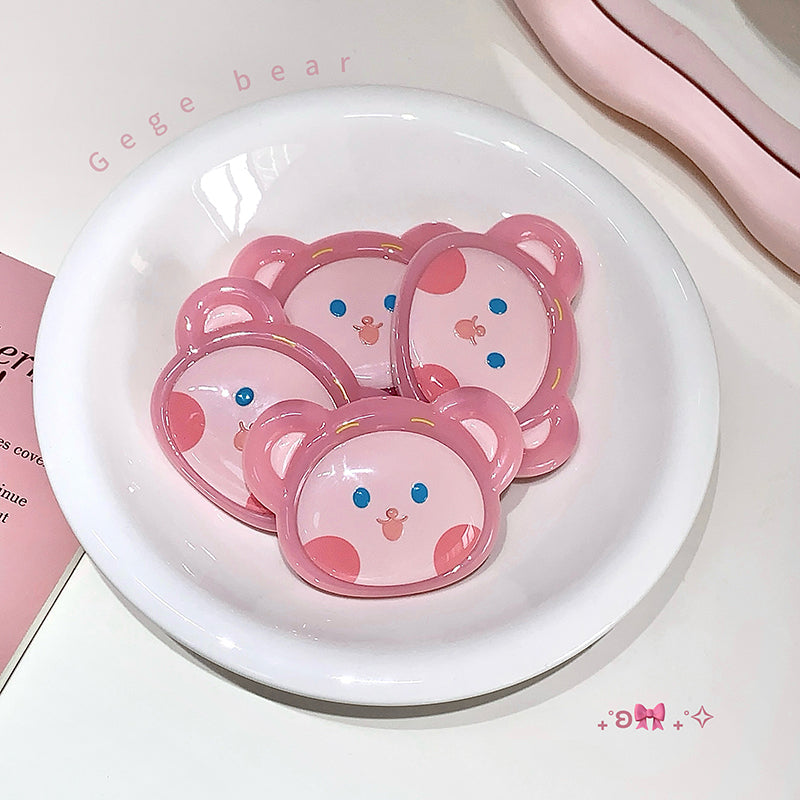 Pink bear-shaped pacifiers in a white dish with 'Gege bear' branding.