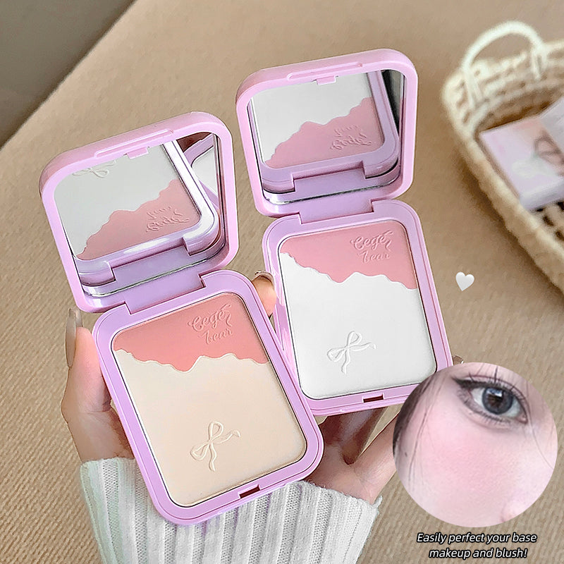 Pink makeup compact with mirror held by a hand, on a beige background.
