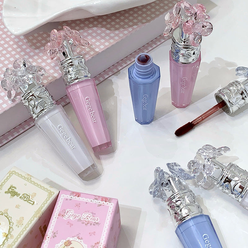 Makeup products with decorative caps on a white surface