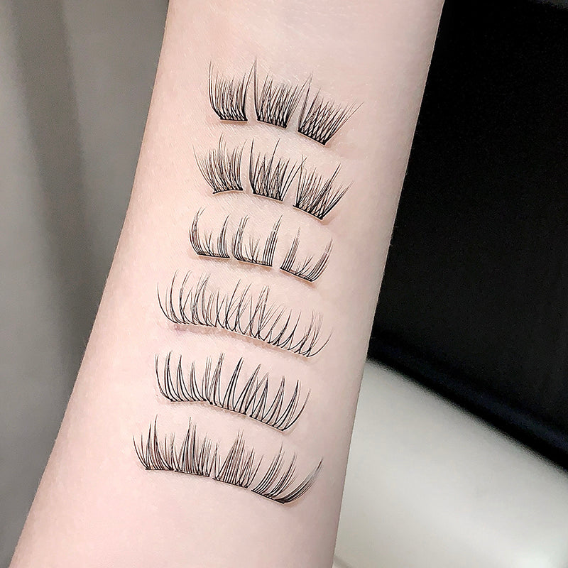 Set of false eyelashes displayed on a person's arm against a neutral background