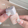 Hand holding a small pink and white container with text indicating features.