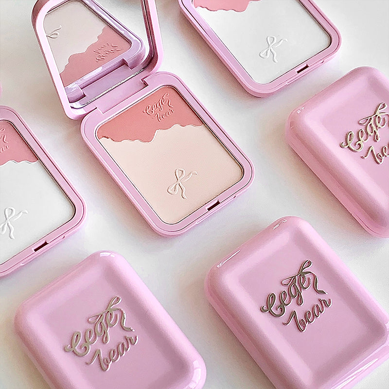Pink makeup compact with 'Elegance' text on a light pink background