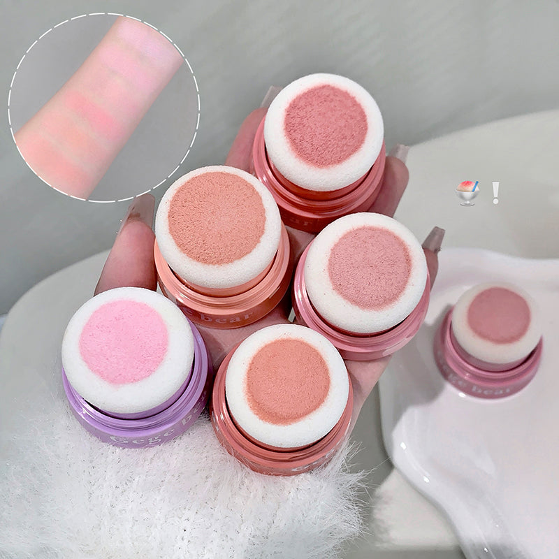 Set of pink and purple cosmetic sponges with close-up of texture on a white surface.