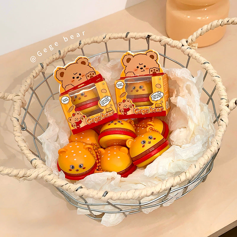 Cartoon bear-shaped toys in packaging inside a woven basket on a beige surface.