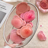 Pink silicone bear-shaped molds in a metal mesh basket on a beige surface.