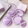 Purple makeup compact with lace detail on a white surface