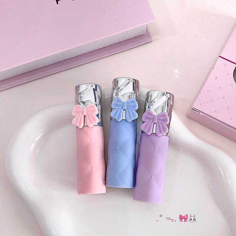 Three small bottles with decorative bows on a heart-shaped surface