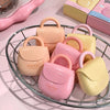 Set of small handbags in pastel colors on a wire rack.