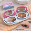 Makeup palette with mirrors and eyeshadow shades on a wooden surface, with a close-up of an eye wearing makeup.