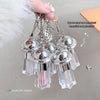 Silver UFO-shaped pendants held by a hand with a neutral background