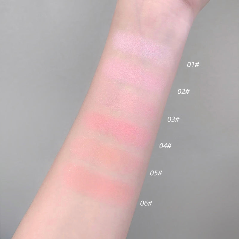 Color swatches of blush on a person's arm with labeled shades against a gray background