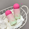 Two pink and green cosmetic products on a white wire basket with a gray background