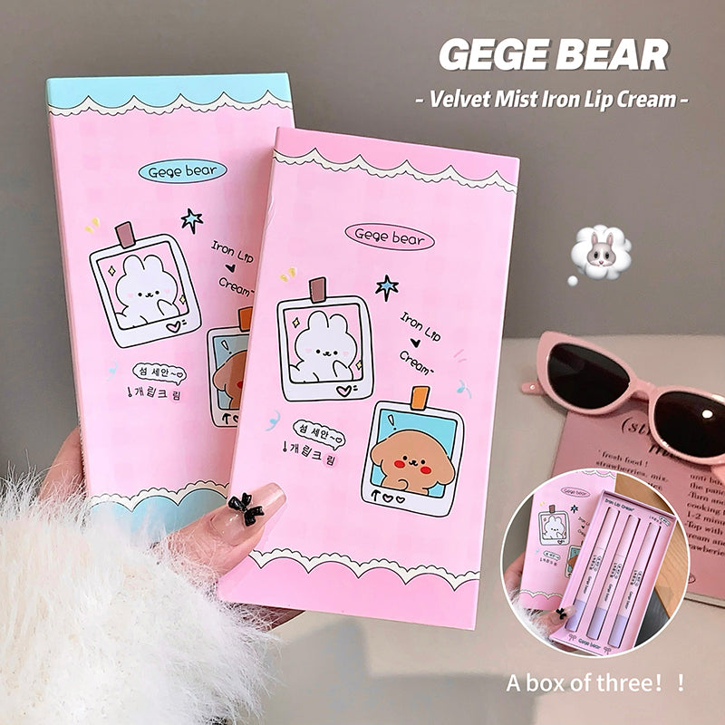 Two pink 'GEGE BEAR' iron lip cream boxes held by a hand, with a close-up of the packaging and sunglasses in the background.