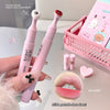 Pink dental brush with text and close-up of teeth, surrounded by small items on a light surface.