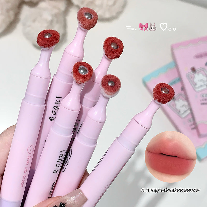 Pink lip brushes with red bristle heads held by a hand, with a close-up of a lip and product description text.