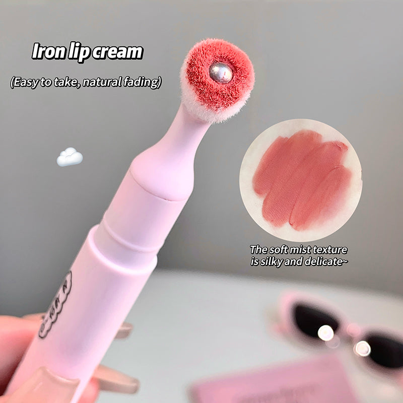 Lip cream applicator with red applicator head and white handle, showing lip color swatch on gray background.